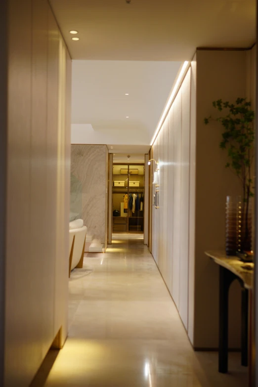 a narrow hallway with a lamp lit and a vase with flowers