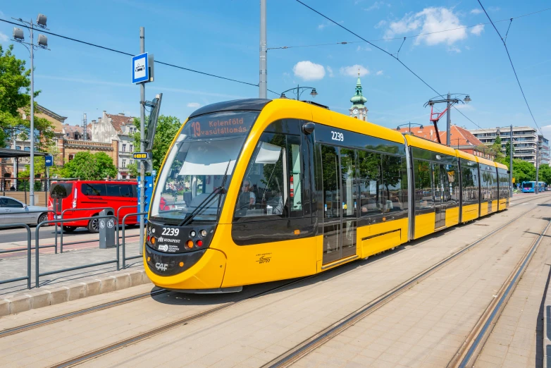 a light rail car on tracks with buildings in the background