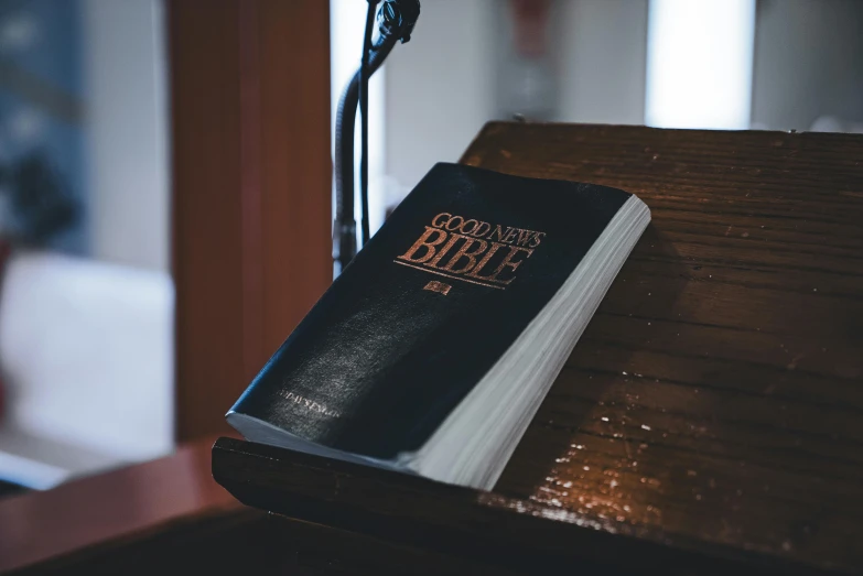 a book resting on a wooden desk with microphone