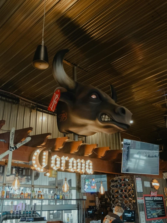 the interior of a restaurant that is decorated with wooden signs and hanging art