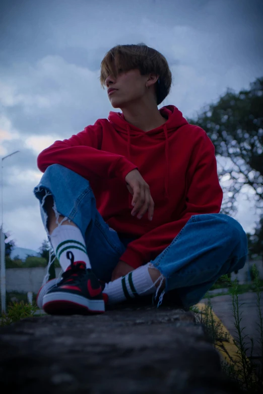 a young person sitting on the ground with a skateboard