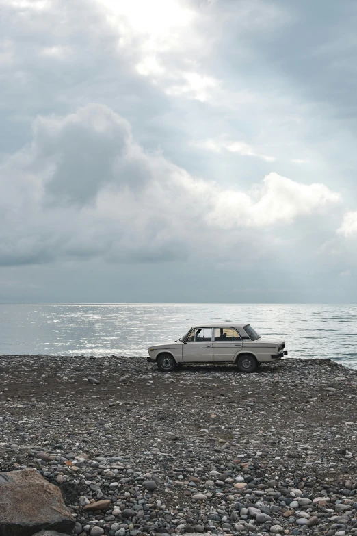 a car parked on rocks by the water