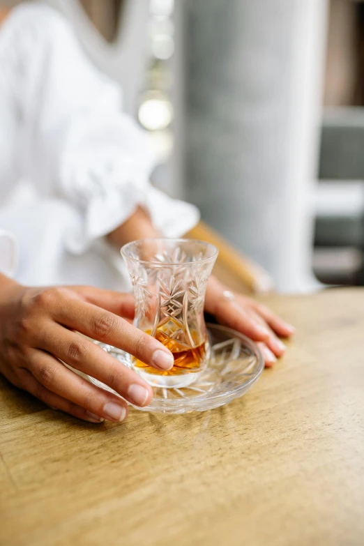 a female with long nails is putting some kind of glass