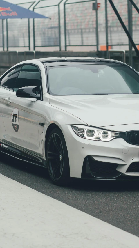 the front of a white bmw car on a race track