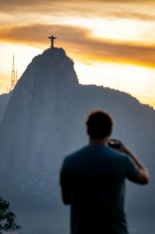 a man in the mountains with the cross on top