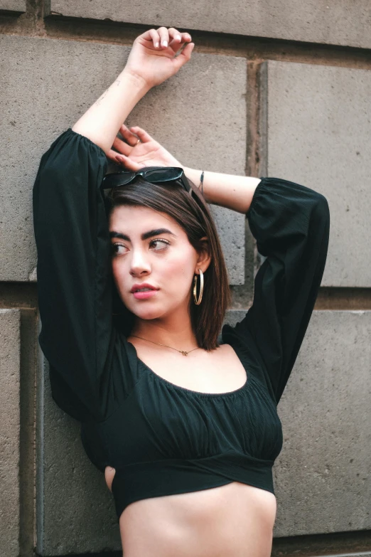 a woman leaning up against a concrete wall