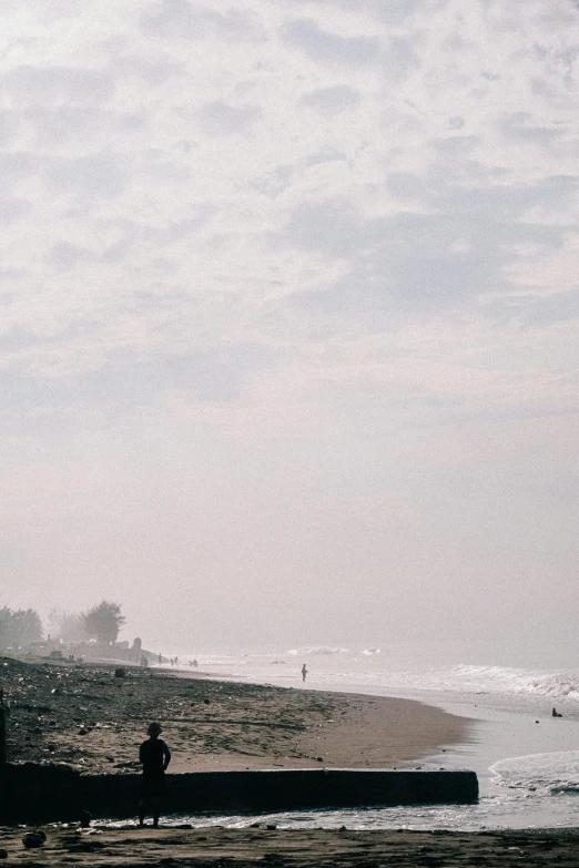 a man sitting on top of a pier next to the ocean