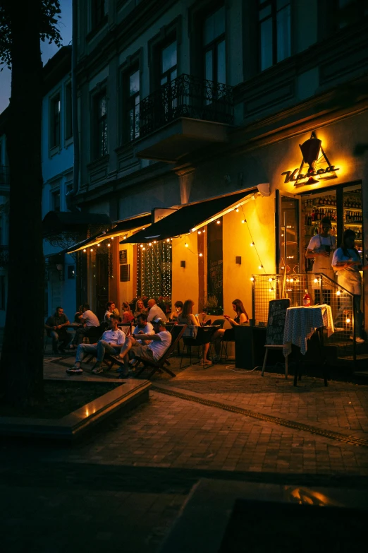 people sitting around in a dimly lit area outside a restaurant