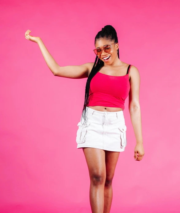 a woman in a red shirt and white shorts poses for the camera