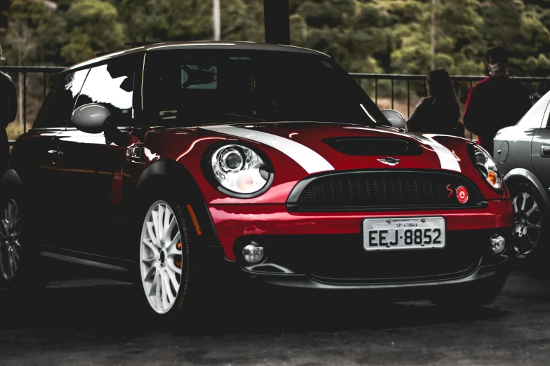 a small red and white car next to two smaller gray cars