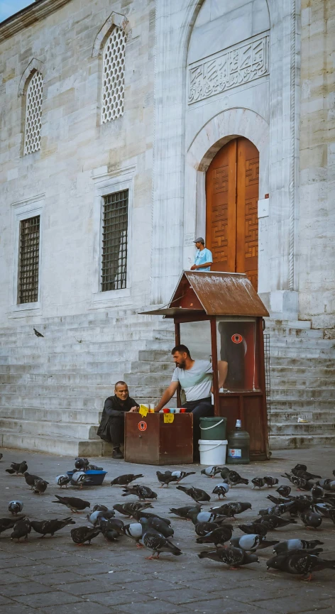 some people are setting in front of a building