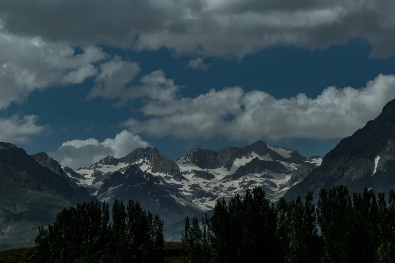 the mountains with trees against a dark sky