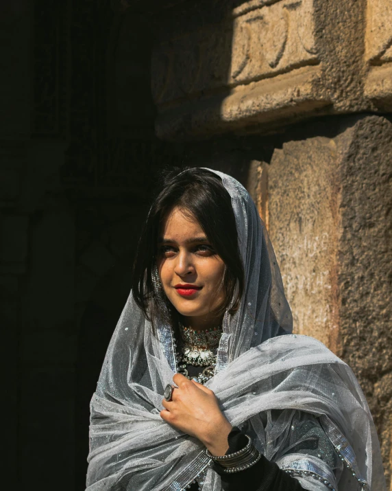 a young woman wearing an elaborate veil and posing for the camera