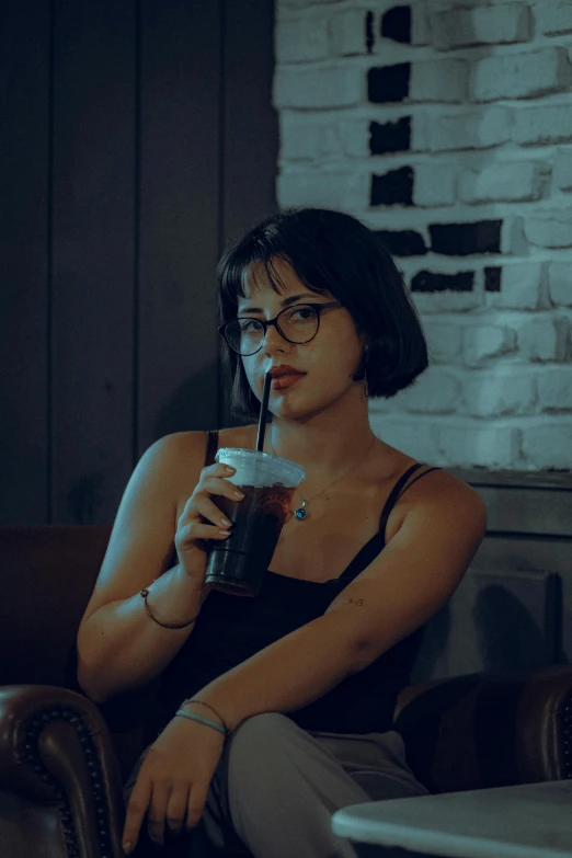 a woman in glasses drinking out of a glass