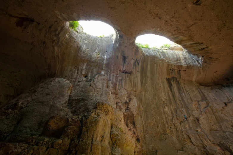 a very long cave wall with a light coming through two windows