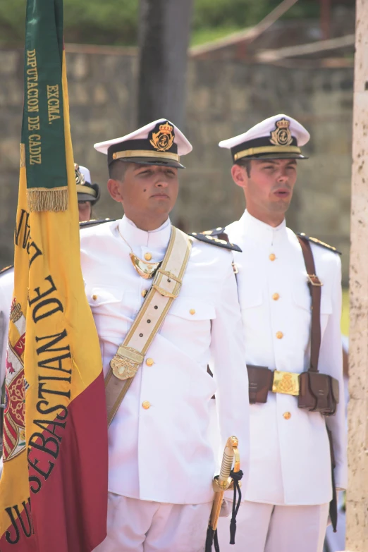 two military officers are saluting in full dress attire