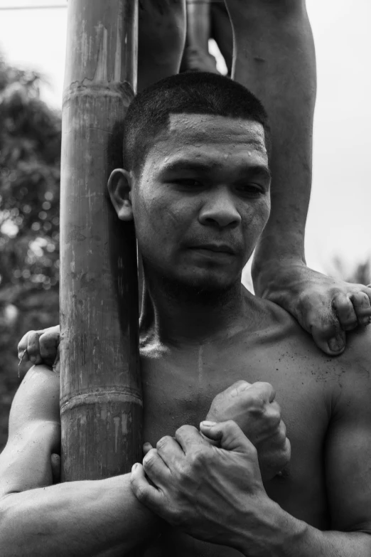 a young man holding onto a large pole