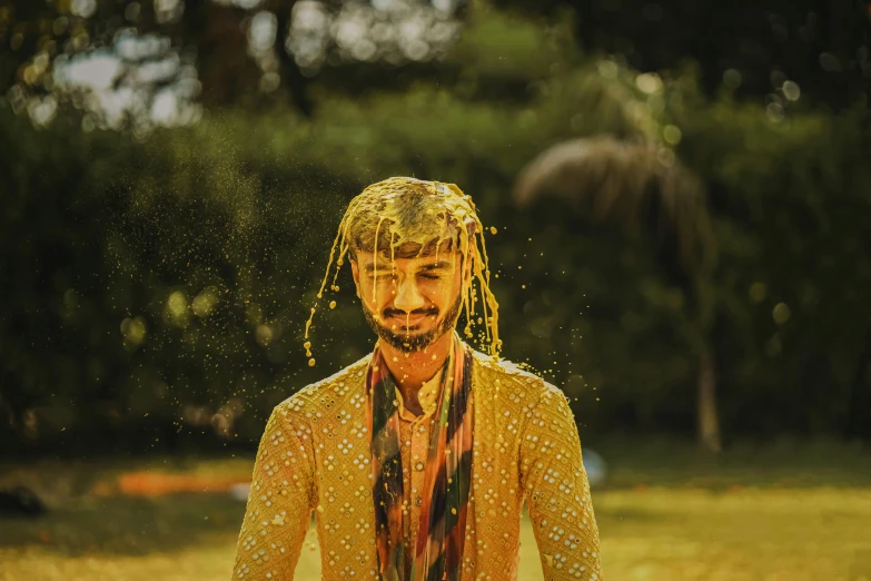 a man with yellow dreadlocks and a long hair covered in water