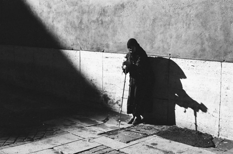 a person leaning against a wall next to a cement wall