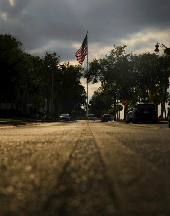 a large flag on a pole in the middle of a road