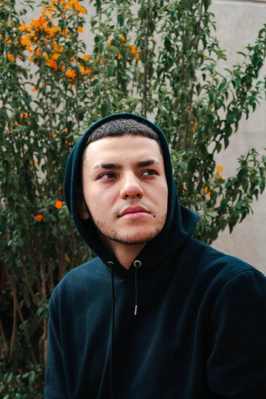 a man wearing a hoodie and staring at the camera