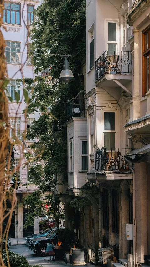 several balconies that line a street near trees and buildings