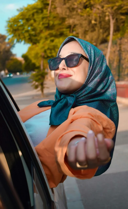 a person that is in a car holding her hands out the window