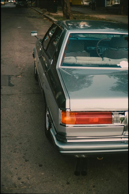 a very long silver car parked in the street