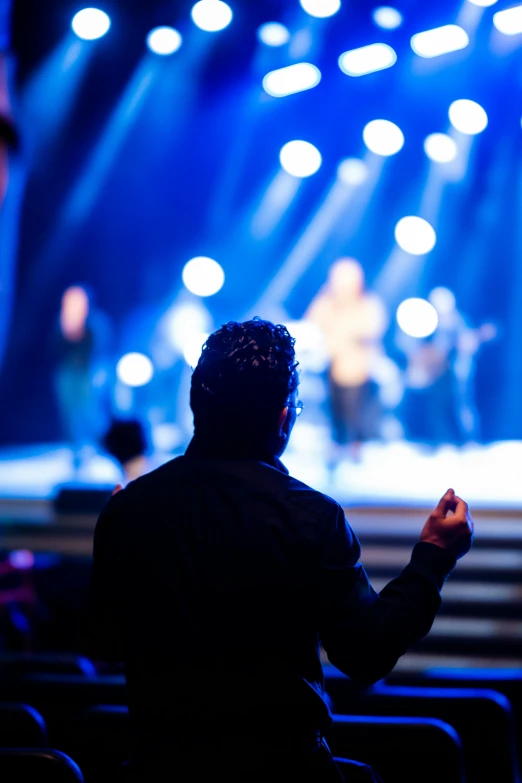 the man is facing an audience at a concert