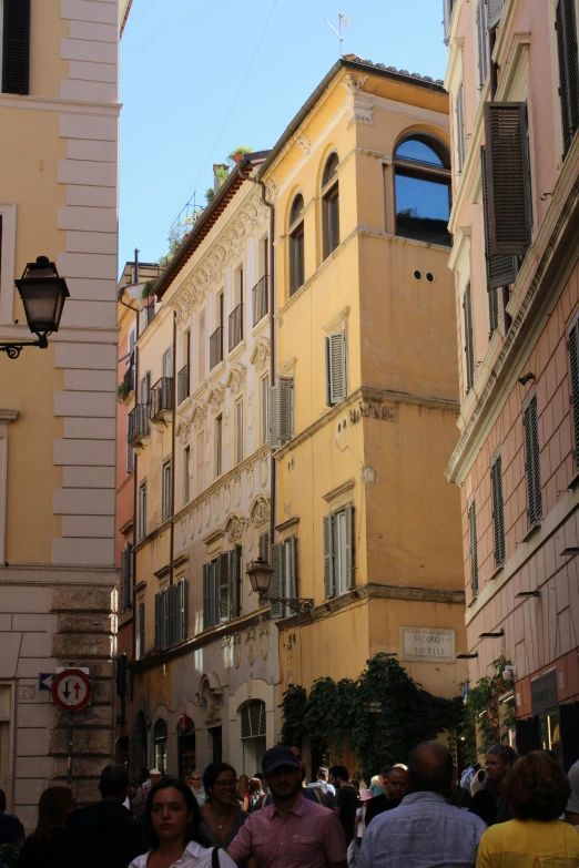 people are walking along an old street in the city