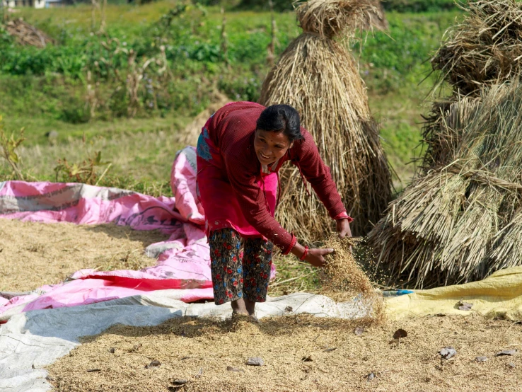 an indian woman is washing clothes near many grass - covered huts