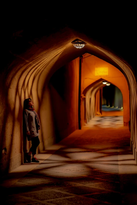 a woman standing in an arch shaped tunnel