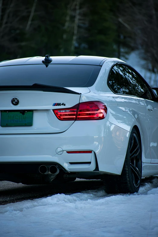 the white bmw sedan parked on the snow