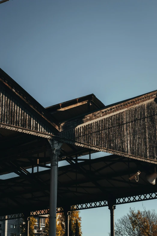 a clock tower in the back ground of an outdoor covered structure