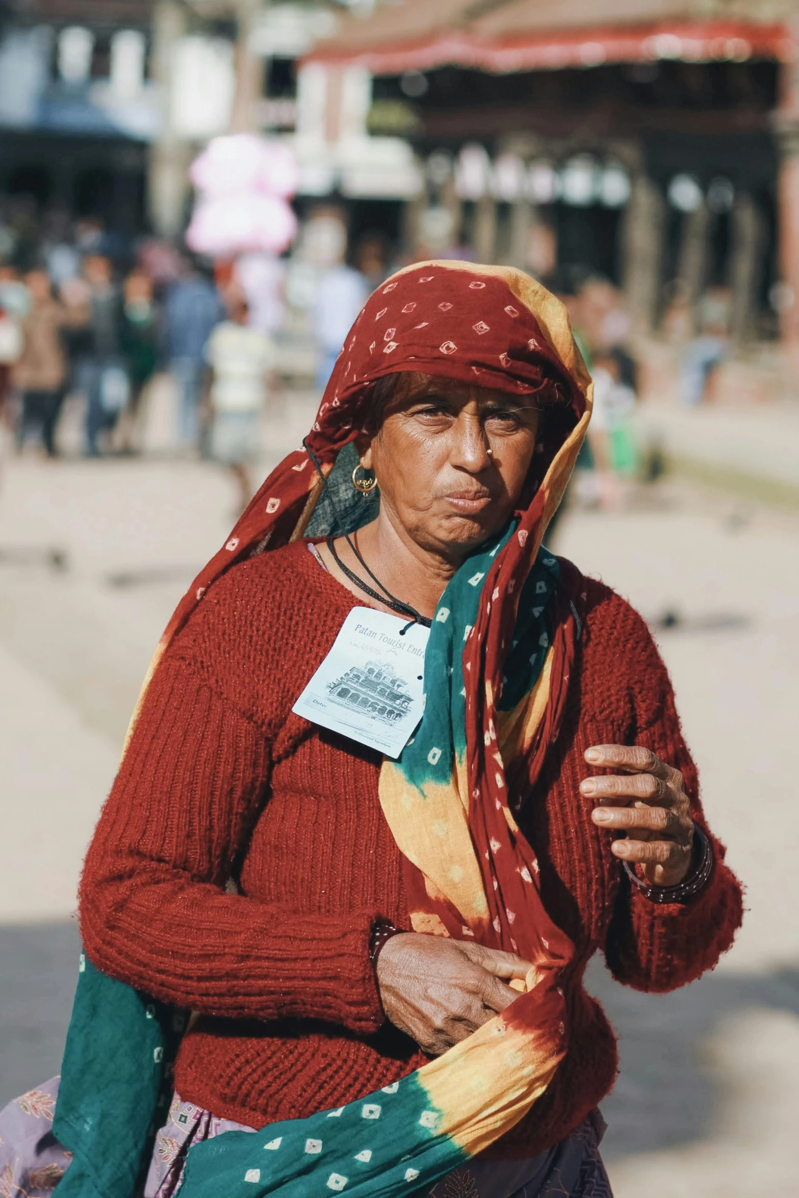 a woman carrying a scarf with a badge on it