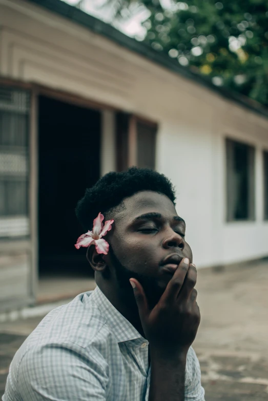 a man with a flower in his hair looking down