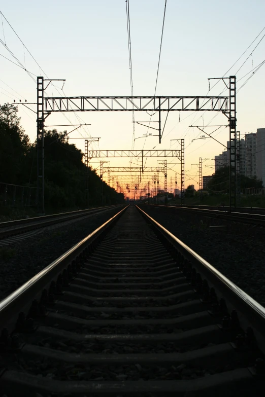 the sun is setting over a railroad track