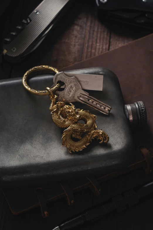 a golden snake keychain with a chain wrapped around it