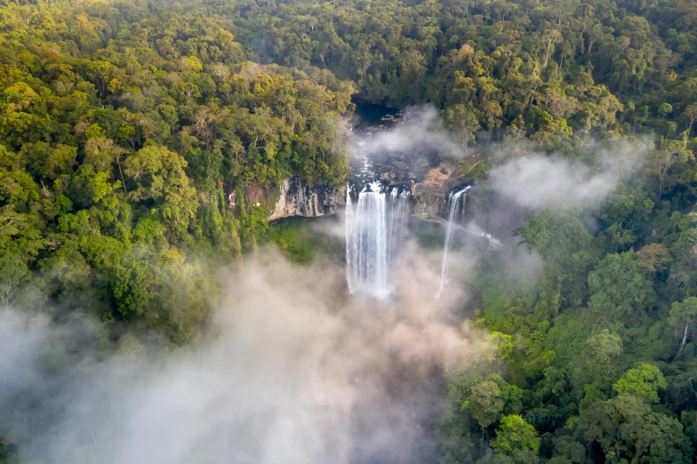 the view from the air shows waterfalls surrounded by green trees