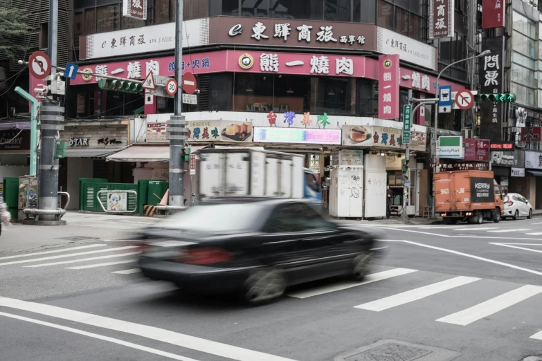 the blurry car drives by on the street with asian advertits