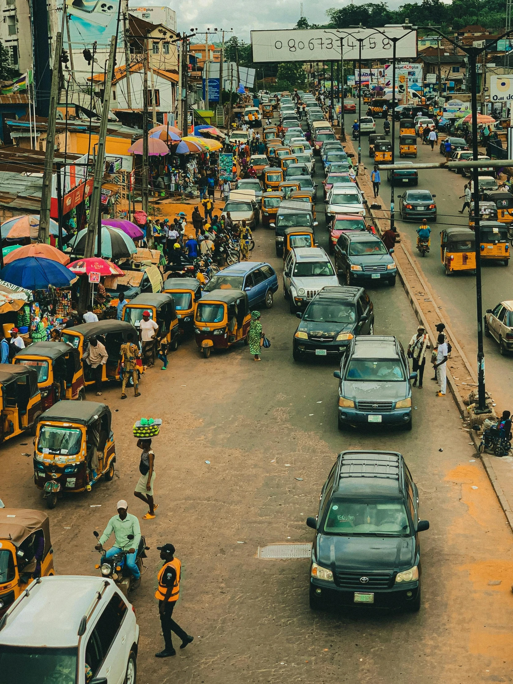 people and cars traveling down the busy city street