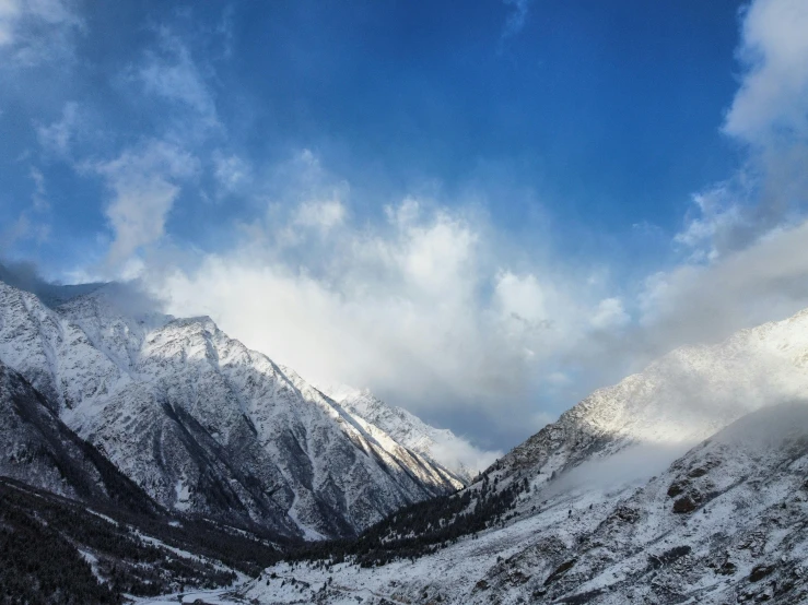 a mountain scene with some snow and blue sky