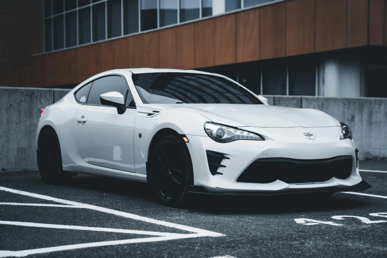 a white sports car is parked near a building