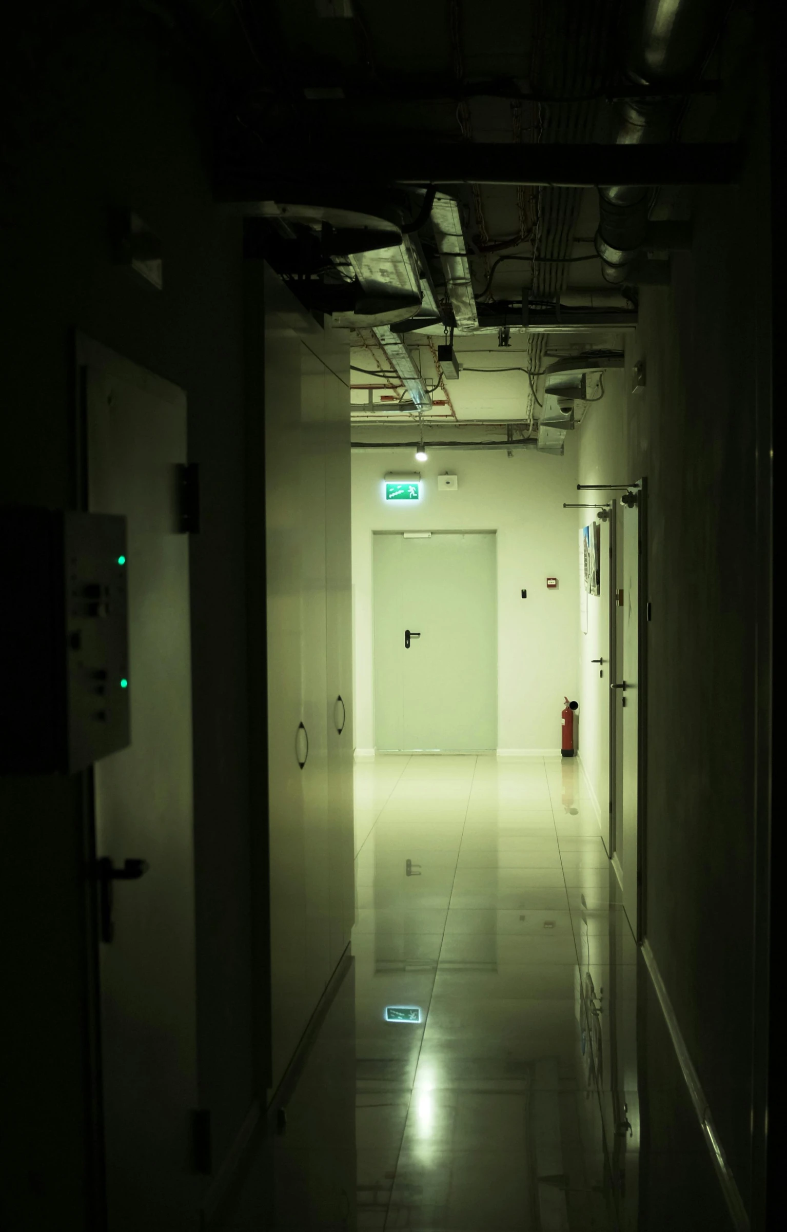 a dark hallway with two elevators in the center