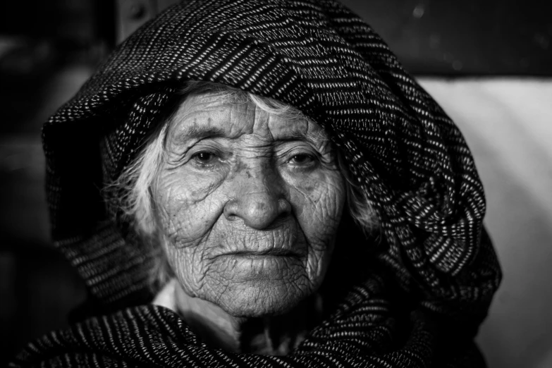 an elderly woman has a scarf around her head