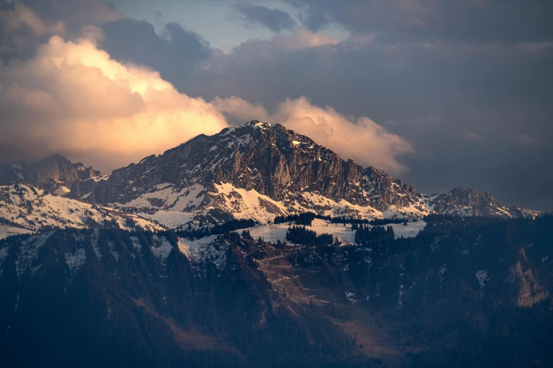 a snow covered mountain sits in the clouds