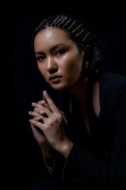 a woman in black dress with her hands folded