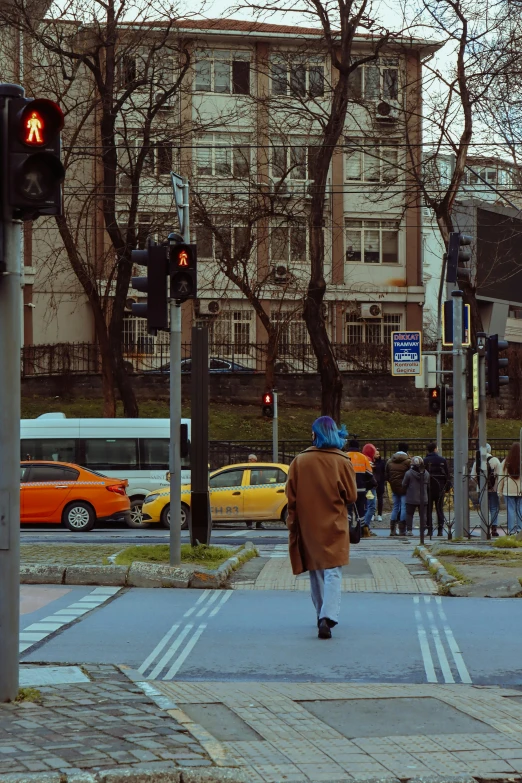 the pedestrian crosswalk is at an intersection as cars pass by