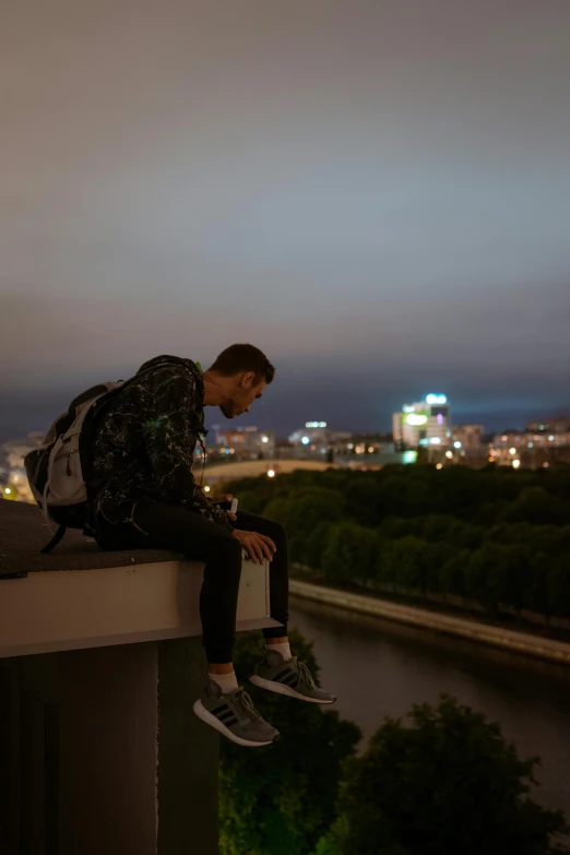 a man is sitting alone with his backpack