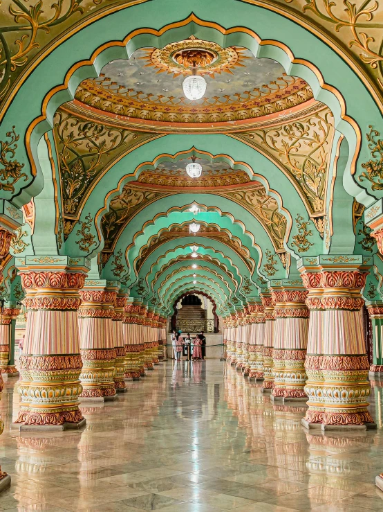 people walk underneath a decorated ceiling and arches